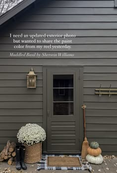 the front door of a gray house with fall decorations