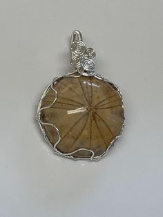 a piece of jewelry is shown on a white surface with a silver wire around it