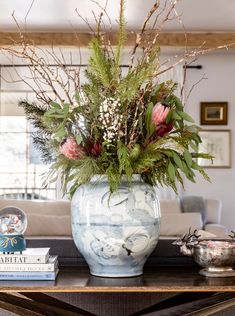 a vase filled with flowers sitting on top of a wooden table next to a book