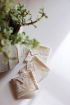 three pieces of cloth sitting on top of a table next to a potted plant