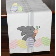 a table runner with an elephant and eggs on it