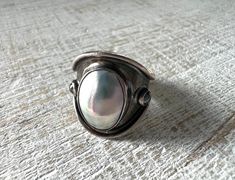 This is a vintage mabe or blister pearl ring with thick band. It is sterling silver and signed by the artist or maker. It is hard to read the maker's signature. It is a size 5.5 and in good condition. Thick Band Ring, Pearl Ring, Rings Statement, Earings Piercings, Vintage Sterling Silver, Band Ring, Band Rings, Statement Rings, Jewelry Rings