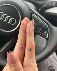 a person with two tattoos on their fingers and one has the word love written on it