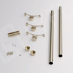 an assortment of metal objects on a white surface with screws, rods and nuts