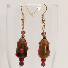 Hand Crafted Earrings. Glass Beads In Amber/Brown With Dark Red Dots, Red, And Smoky Brownish Lavender. Gold Tone Hardware And Accent Bead. J-Hook Style. Picture With Aaa Battery For Size Comparison. 2 1/8 Inches Drop Smoke Free, Pet Free Home. Handmade Jewelry Gold Glass Earrings With Dangling Beads, Elegant Adjustable Beaded Glass Earrings, Glass Beaded Earrings With Dangling Beads For Gift, Elegant Glass Beaded Drop Earrings, Adjustable Glass Beaded Earrings With Dangling Beads, Glass Bead Dangling Drop Earrings, Beaded Glass Drop Earrings, Glass Beaded Drop Earrings, Glass Beaded Dangle Earrings For Parties