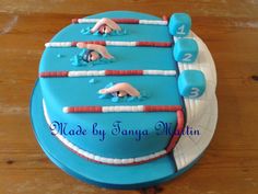 a cake that is decorated to look like a swimming pool with swimmers and numbers on it