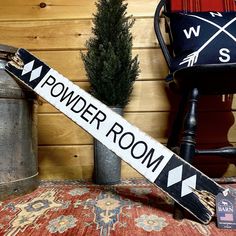 a wooden sign sitting on top of a chair next to a potted pine tree