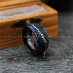 a black and blue ring with football stitching on it, sitting next to a wooden box