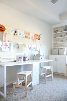 a child's desk and chair in a room with lots of pictures on the wall