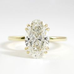 an oval cut diamond ring in yellow gold