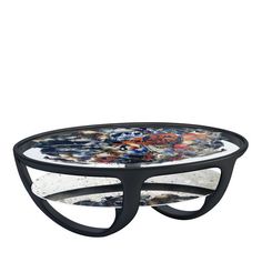 a glass and metal coffee table with an artistic design on it's top, against a white background