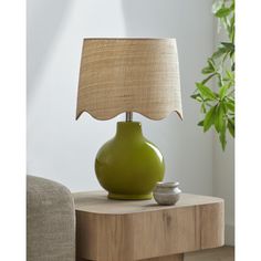 a green lamp sitting on top of a wooden table