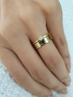 a woman's hand wearing a gold ring with a diamond on it and a white towel