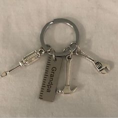 a metal keychain that has a measuring tape and an anchor on it's side