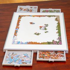 three pieces of puzzle sitting on top of a wooden table next to another piece of artwork