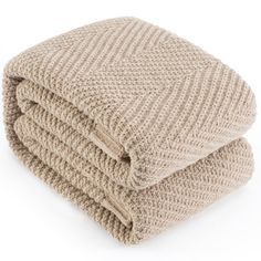 two blankets folded on top of each other in different colors and patterns, one is light brown