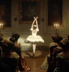 a ballerina is dancing in front of an audience