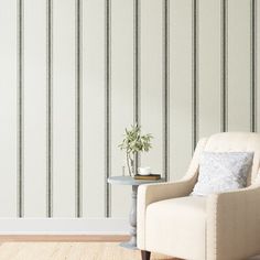 a chair and table in front of a striped wallpapered room with a potted plant