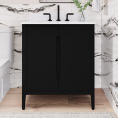 a white toilet sitting next to a black cabinet in a bathroom with marble walls and floor