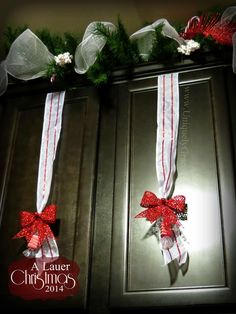 two christmas wreaths with bows and ribbons on top of each other in front of a door