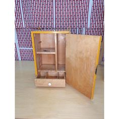 an open wooden cabinet sitting on top of a table