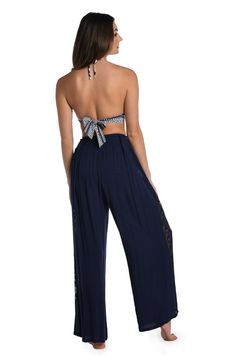 These palazzo pants get their boho-inspired style from crocheted side panels. Perfect for pulling on post dip, you can wear them as a swimsuit cover-up but they also look fabulous with a tank or cami for an effortlessly chic look. A gently elasticized waist offers a comfortable fit. [split] Details Palazzo-style beach pants Elasticized waistband Wide legs for a flowy fit Lightweight rayon fabric Fabric 100% Rayon Stretch Wide-leg Harem Pants For Beach, Chic Harem Pants For Vacation, Beach Harem Pants With Stretch And Wide Leg, Summer Beach Bottoms With Crochet Trim, Bohemian Summer Bottoms With Crochet Trim, Bohemian Bottoms With Crochet Trim For Summer, Sleeveless Bohemian Beach Cover-up Bottoms, Chic Halter Neck Bottoms For The Beach, Chic High Waist Harem Pants For Beach