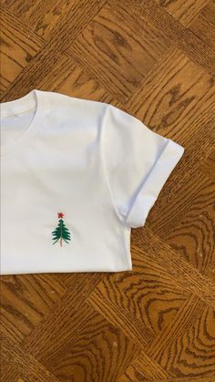 Hand Embroidered T-Shirt White Christmas Tops With Embroidered Graphics, Christmas White Embroidered Tops, White Tops With Embroidered Logo For Christmas, White Top With Embroidered Logo For Christmas, White Tops With Custom Embroidery For Christmas, White Embroidered Crew Neck Shirt, Christmas Cotton Top With Embroidered Text, Holiday Embroidered Cotton Top, White Embroidered Crew Neck T-shirt