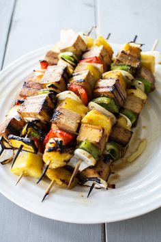 grilled chicken and pineapple kabobs on a white plate with toothpicks