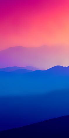 the sky is pink and blue with mountains in the background