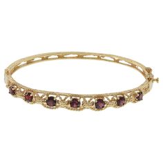 Add a touch of classic glamour to your wardrobe with this retro bangle. Made of luxurious 14KT yellow gold and adorned with 2.00CT-TW of round cut garnets, this piece exudes elegance. The intricate filigree design adds an extra layer of sophistication. Weighing in at 13.7 grams, this bracelet is substantial and will make a statement wherever you wear it. Elevate your style with this timeless and opulent accessory. Smokey Topaz Ring, Classic Glamour, Retro Bracelet, Retro Era, Smokey Topaz, Vintage Bangles, Diamond Bangles Bracelet, Garnet Bracelet, Garnet Stone