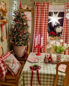 a christmas tree in the corner of a room with plaid tablecloths and decorations