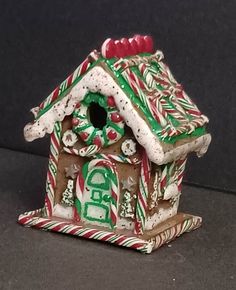 a ceramic birdhouse decorated with candy canes and decorations