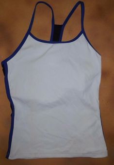 This is new with the original SAMPLE hang tag from Body Wrappers, 8462. This is a pullover camisole top with a racer back. The color is white with royal blue and black detail.  The size is a medium adult, and it is bodice lined in white.  Please refer to the measurement guide provided with the pictures to confirm a good fit. I have listed it with defects because of a dark smudge on the right side, see close up picture.  This item belonged to my Body Wrappers sales rep, and has not Sportswear Training Top With Tank Straps, Sportswear Tops With Tank Straps For Sports, White Sleeveless Workout Camisole, Sports Tank Camisole, Sporty Tank Camisole For Gym, White Workout Tank Camisole, Sporty Stretch Camisole, White Sporty Camisole Tank Top, White Sporty Camisole Tops