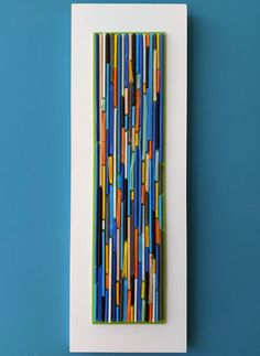 an art piece made out of colored pencils on a blue background with a white frame