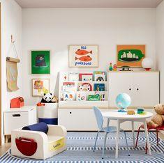 a child's playroom with toys, bookshelves and art on the walls