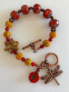 a close up of a bracelet on a table with beads and charms attached to it