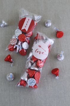 two bags filled with valentine's day candies on top of a gray table