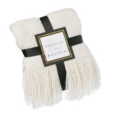 a white and black blanket with fringes on the bottom, tied in a ribbon