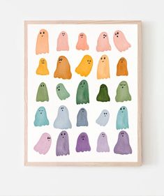 watercolor ghost print in various colors on a white wall above a wooden framed frame