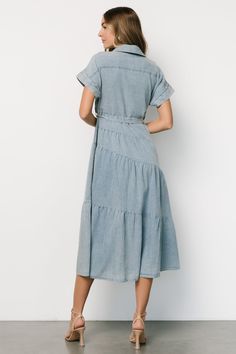 Baltic Born exclusive style Washed denim blue color Cotton-poly blend material has no stretch Collared Functional buttons down front of dress Cuffed short sleeves Removable self-tie waist sash Tiered skirt Unlined 90% Cotton, 10% Polyester Casey is 5'8, cup size 32B, size 2 and wearing size S Button Up Maxi Dress, Baltic Born, Semi Casual, Waist Sash, Dress Denim, Cuffed Shorts, Button Up Dress, 80 Dress, Tiered Maxi Dress