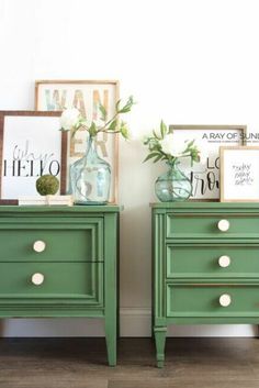 two green dressers with flowers in vases on top and framed pictures above them