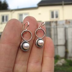 A minimal and modern look with a nod to old school pearl earrings. These sterling silver and pearl earrings are set in a modern round shadow bezel style and hang from sculptural open circles. The cultured pearl is half drilled on the bottom and glued to a sterling post soldered to the necklace for durability. You will get a lot of compliments when wearing this mini art piece. To see all my pearl jewelry go here: https://www.etsy.com/shop/marmarModern?ref=seller-platform-mcnav&section_id=1328 Modern Pearl Drop Earrings For Anniversary, Modern Round Sterling Silver Pearl Earrings, Silver Minimalist Pierced Pearl Earrings, Modern Round Pearl Earrings, Modern Everyday Dangle Pearl Earrings, Modern Dangle Pearl Earrings For Everyday, Modern Silver Pierced Pearl Earrings, Minimalist Round Pearl Drop Earrings, Modern Sterling Silver Pearl Earrings