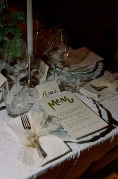 a table set for dinner with menus and wine glasses