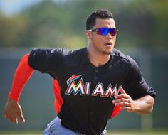 a baseball player is running on the field with his arm extended and wearing sunglasses that read miami