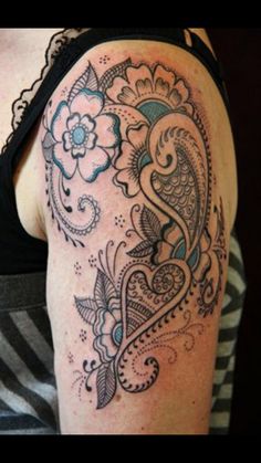 a woman's arm with an intricate tattoo design on the back of her shoulder