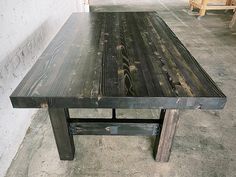 a wooden table sitting on top of a cement floor