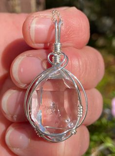 A rare and unique enhydro Herkimer Diamond quartz crystal, artfully wire wrapped in sterling silver. This beautiful pendant features a natural, 15x24 mm, sparkling clear Herkimer Diamond quartz crystal we mined in Middleville NY. The crystal has great form and clarity, a couple tiny baby rider crystals, a small inclusion, a small extra face, and a water cavity with a small bubble that does not move. See all photos and video and look for the small bubble in the center of the crystal. Looks even b Gift Herkimer Diamond Necklace In Silver, Handmade Clear Quartz Jewelry, Handmade Clear Drop Jewelry, Silver Wire Wrapped Jewelry With Mineral Crystal, Wire Wrapped Silver Crystals For Healing, Sterling Silver Gemstone Pendant Crystal, Silver Wire Wrapped Crystals For Jewelry Making, Silver Wire Wrapped Crystal Jewelry, Faceted Crystals As Gifts