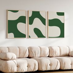 a living room with two paintings on the wall and a couch in front of it