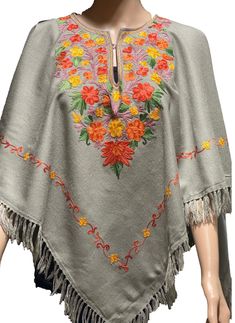 Floral Embroidery  Poncho Crafted from wool blends. Wear it over a shirt, with pants, jeans or leggings.  The exquisite embroidered design is on the front, sides and back.  The Poncho does  not have sleeves or any fittings, the poncho is designed to go over the head and sit around the shoulders free style. the edges have tassel fringes around the entire bottom of the poncho. The neck has an eye and hook, It is also lined with complementing fabric for comfort. The floral multi colored Ari needle embroidery uses  natural plant dye thread.  Color; Ocean blue or stone gray- color can vary due to lighting   Free style Fit Size   42'X42' Shoulder to hem 32' (inch) with Fringe Fabric; Wool Made in a smoke and Pet free home. Made in Kashmir,India Fall Folk Embroidered Poncho, Traditional Poncho With Floral Embroidery, Embroidered One-size Poncho For Fall, Embroidered One Size Poncho For Fall, One Size Embroidered Poncho For Fall, Winter Festival Embroidered Poncho, Embroidered Poncho For Fall, One Size, Traditional Embroidered Winter Poncho, Traditional Embroidered Poncho For Winter