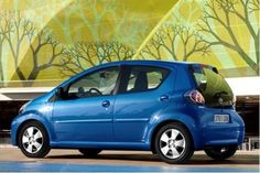 a small blue car parked in front of a building